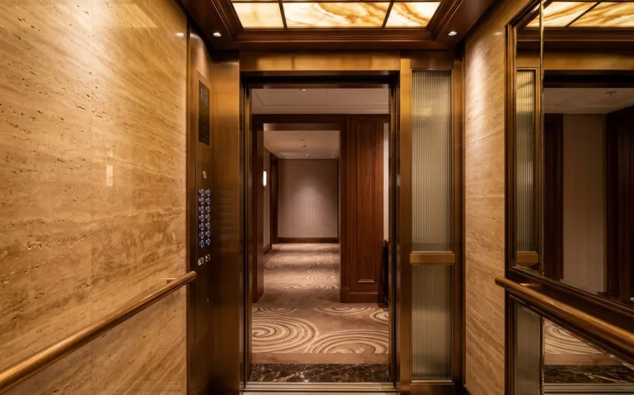 Hotel lobby with three bronze lift doors in St Julian's